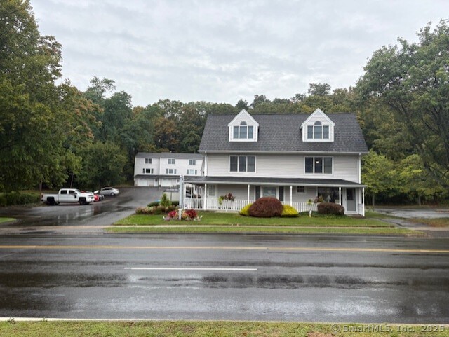 a front view of residential houses with street and trees