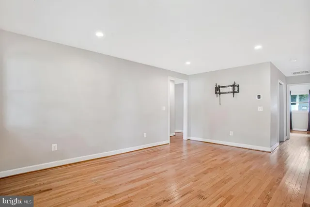 an empty room with wooden floor and window