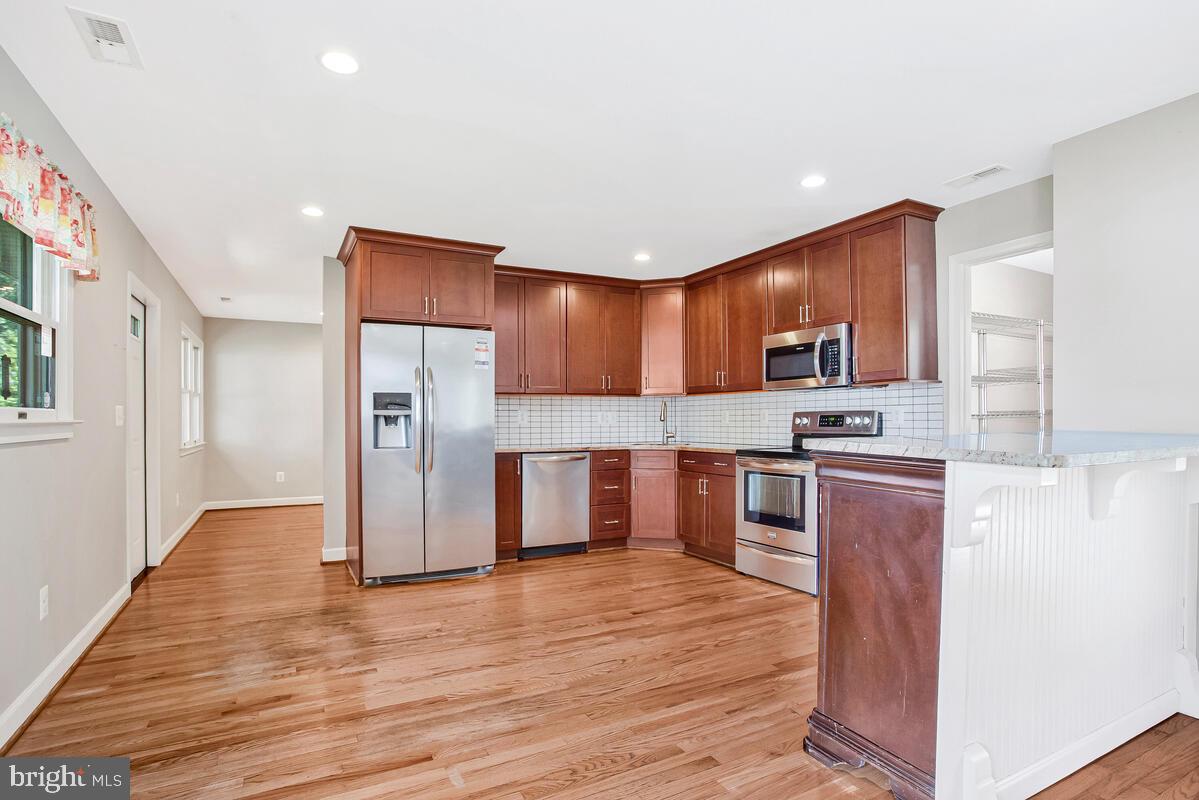 1533 Wakefield Road Edgewater, MD 21037 - Photo 9 of 41 a kitchen with stainless steel appliances a refrigerator and a stove top oven