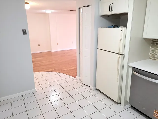 a white refrigerator freezer and a stove sitting inside of a kitchen