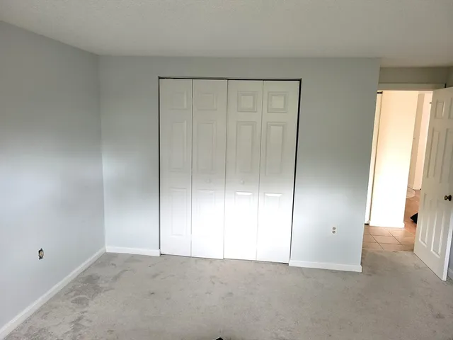 an empty room with windows and closet