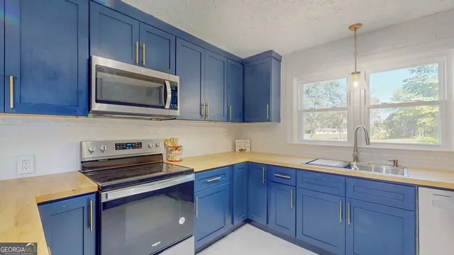 a kitchen with stainless steel appliances granite countertop wooden cabinets a sink and a window