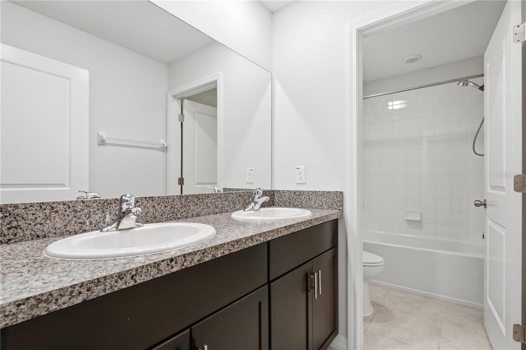 5223 Dandelion Street Apollo Beach, FL 33572 - Photo 16 of 19 a bathroom with a granite countertop sink tub and a mirror