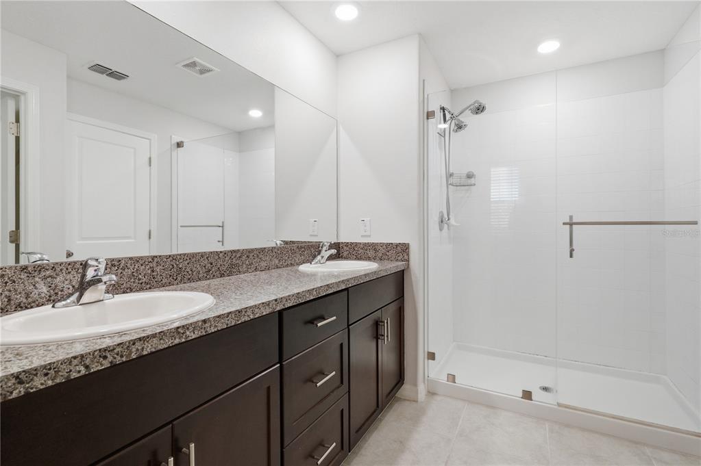 5223 Dandelion Street Apollo Beach, FL 33572 - Photo 17 of 19 a bathroom with a granite countertop sink a mirror a shower and a bathtub