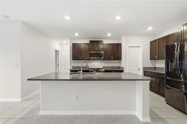 a large kitchen with granite countertop a sink and stainless steel appliances