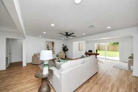 a living room with furniture and a wooden floor
