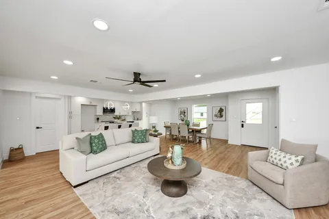 a kitchen with stainless steel appliances kitchen island granite countertop a wooden floor and white cabinets