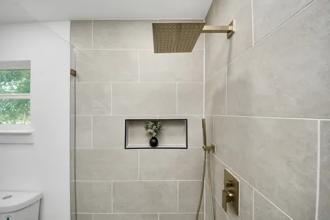 a bathroom with a granite countertop sink mirror and shower