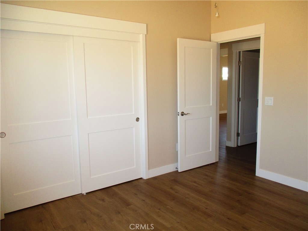 24236 Cahuilla Road Apple Valley, CA 92307 - Photo 17 of 48 an empty room with wooden floor and closet area