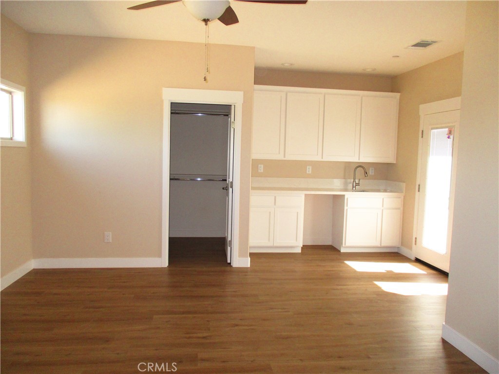 24236 Cahuilla Road Apple Valley, CA 92307 - Photo 20 of 48 a view of a kitchen with a fridge and wooden floor