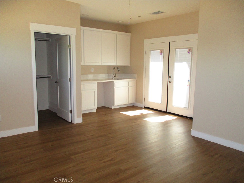 24236 Cahuilla Road Apple Valley, CA 92307 - Photo 22 of 48 a view of a kitchen with wooden floor and a sink