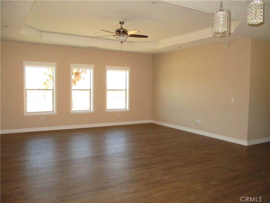 24236 Cahuilla Road Apple Valley, CA 92307 - Photo 10 of 48 a view of an empty room with wooden floor and a window