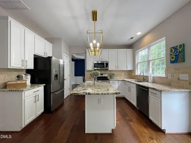 a kitchen with a center island wooden floor cabinets and a window