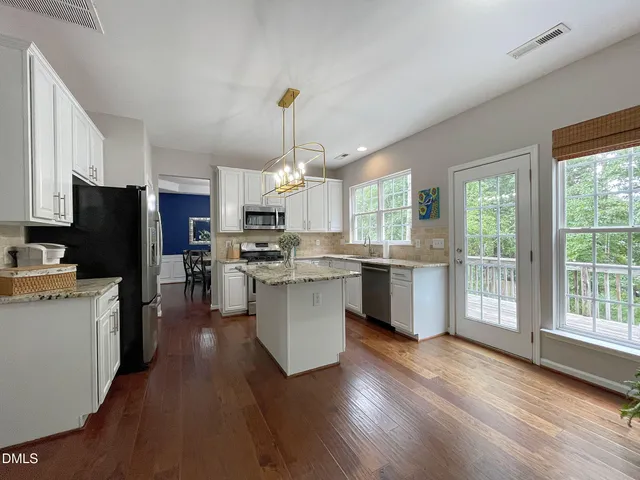 a kitchen with a refrigerator a sink dishwasher stove and oven with wooden floor
