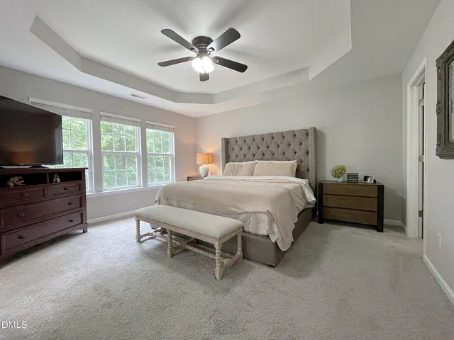 a spacious bedroom with a bed and a flat screen tv