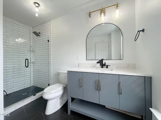 a bathroom with a sink a toilet and shower