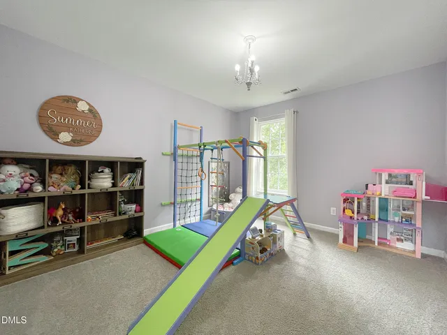 a view of a bedroom with workspace and toys