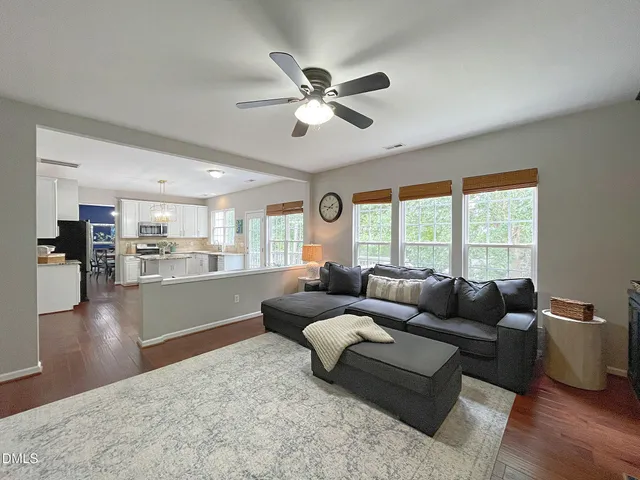 a living room with furniture and a large window with wooden floor