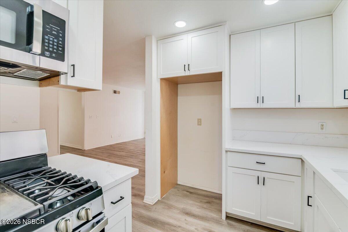 321 North Z Street Lompoc, CA 93436 - Photo 13 of 33 a kitchen with granite countertop white cabinets and white appliances