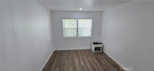 a view of a room with wooden floor and a window