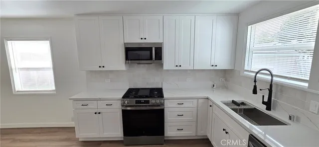 a kitchen with granite countertop a stove and a sink