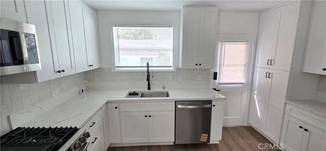 a kitchen with cabinets appliances and a window