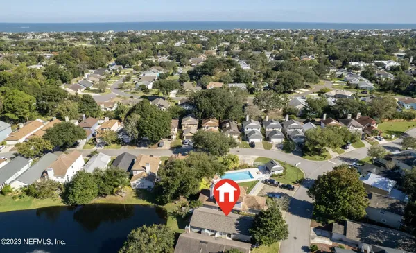 an aerial view of residential houses with outdoor space and lake view