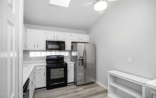 a kitchen with stainless steel appliances granite countertop a sink and a microwave