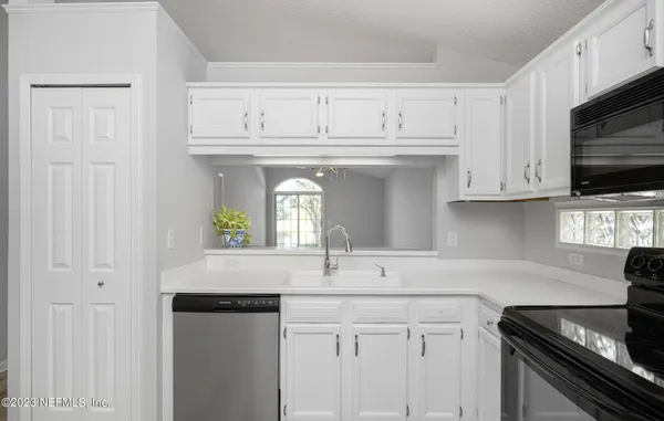 a view of a big room with windows and chandelier