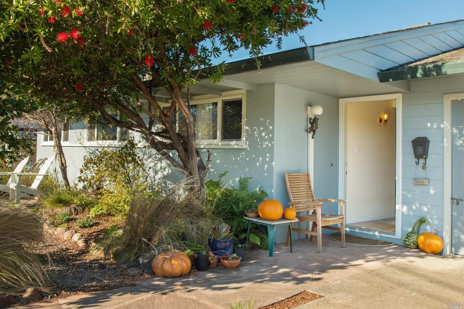 a view of a chair and table in backyard of the house
