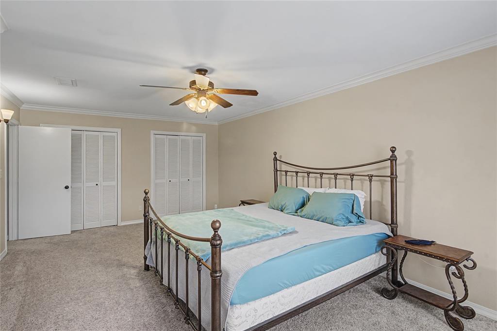 10056 Alondra Street Shreveport, LA 71115 - Photo 26 of 31 a bedroom with a bed and a chandelier