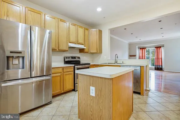a kitchen with stainless steel appliances granite countertop a refrigerator a stove a sink and a refrigerator