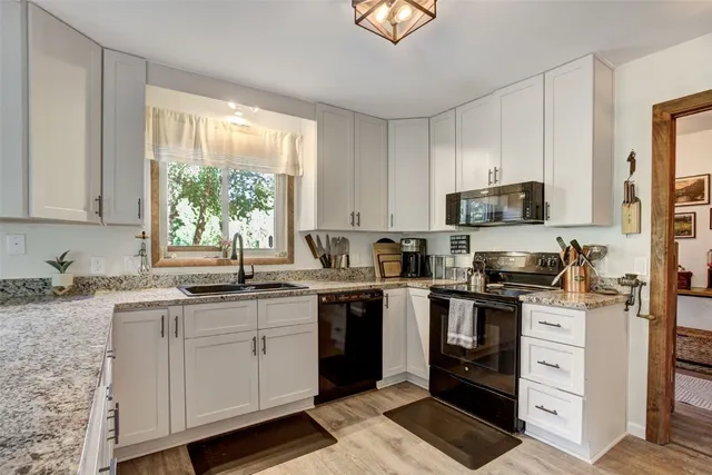 a kitchen with a sink stove top oven and cabinets