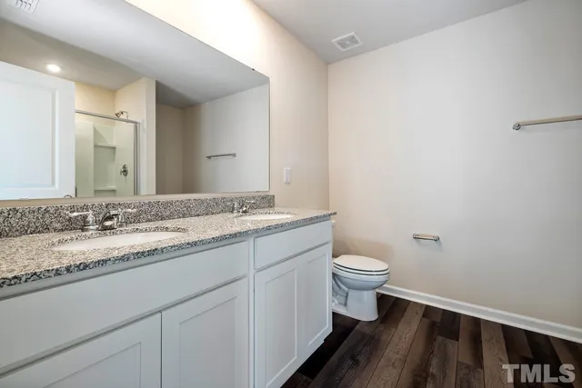 a bathroom with a granite countertop sink a toilet and a mirror