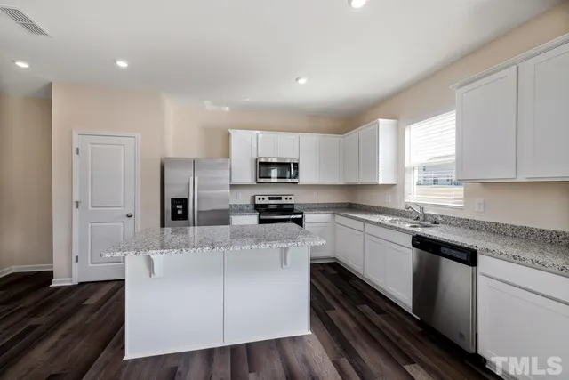 a kitchen with stainless steel appliances granite countertop a stove a sink and a refrigerator