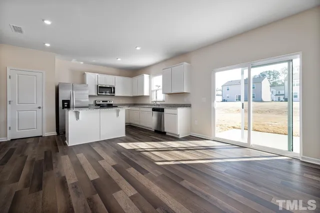 a kitchen with wooden floors and white appliances
