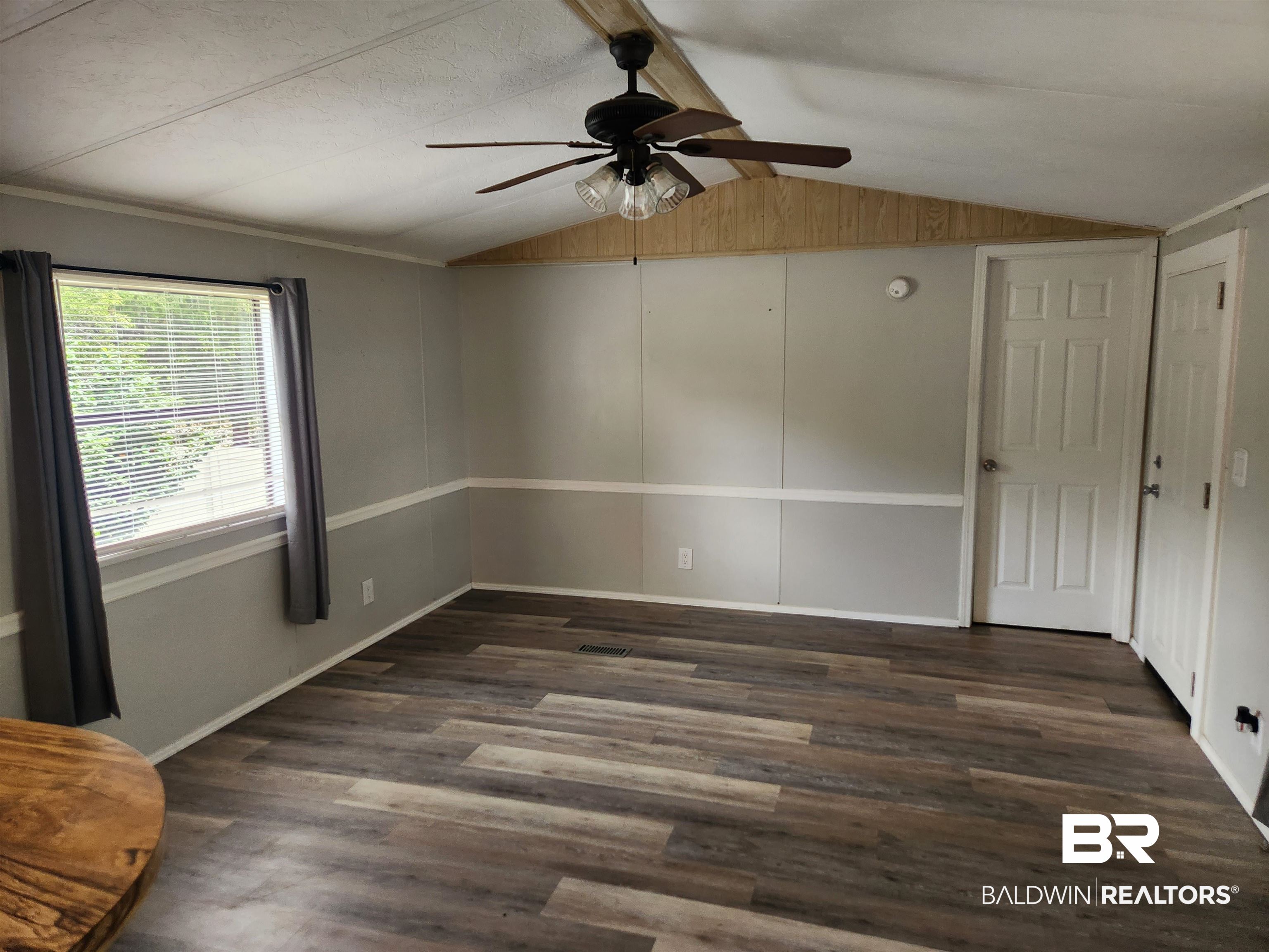 23051 Fritz Lane Foley, AL 36535 - Photo 17 of 26 Spacious interior featuring wood-finish flooring, a ceiling fan, and paneled walls with chair rail molding