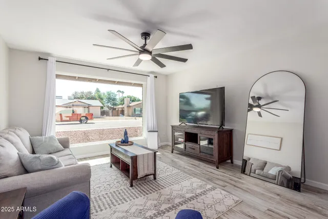 a living room with furniture a window and a flat screen tv