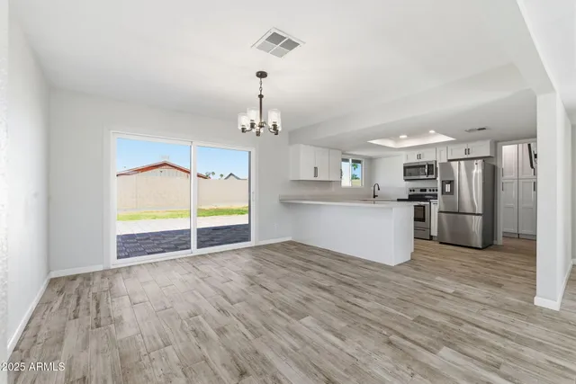 a view of a kitchen with wooden floor electronic appliances and window