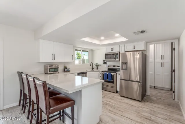 a kitchen with refrigerator cabinets dining table and chairs