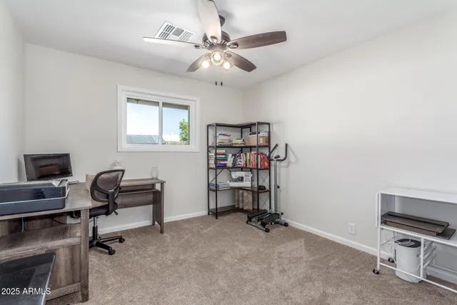 a view of a workspace with furniture and a window