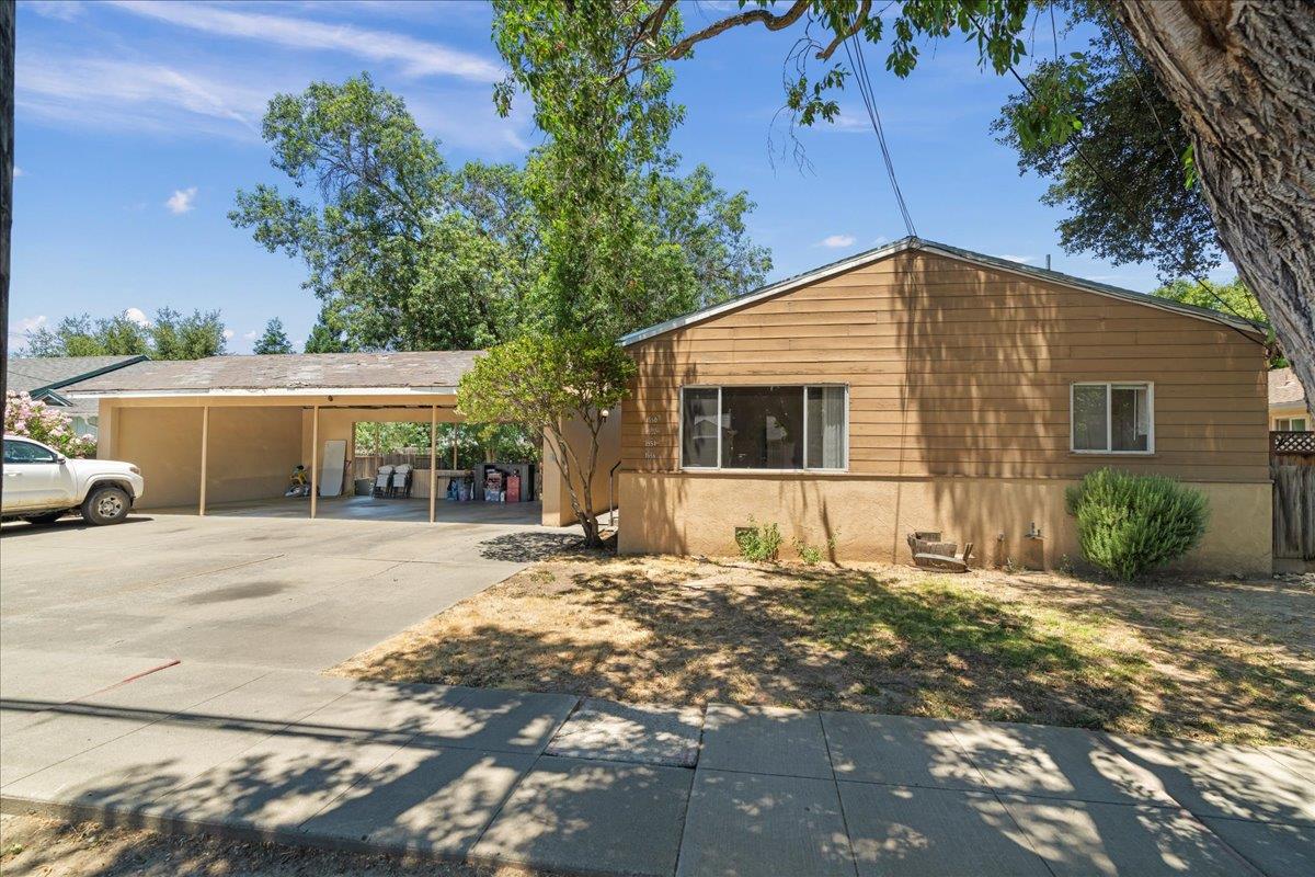 a front view of a house with a yard and potted plants