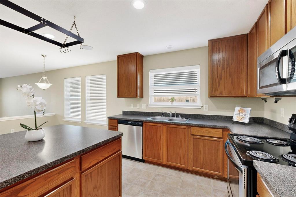 2114 Cypress Way Anna, TX 75409 - Photo 9 of 40 a kitchen with stainless steel appliances a sink stove and cabinets