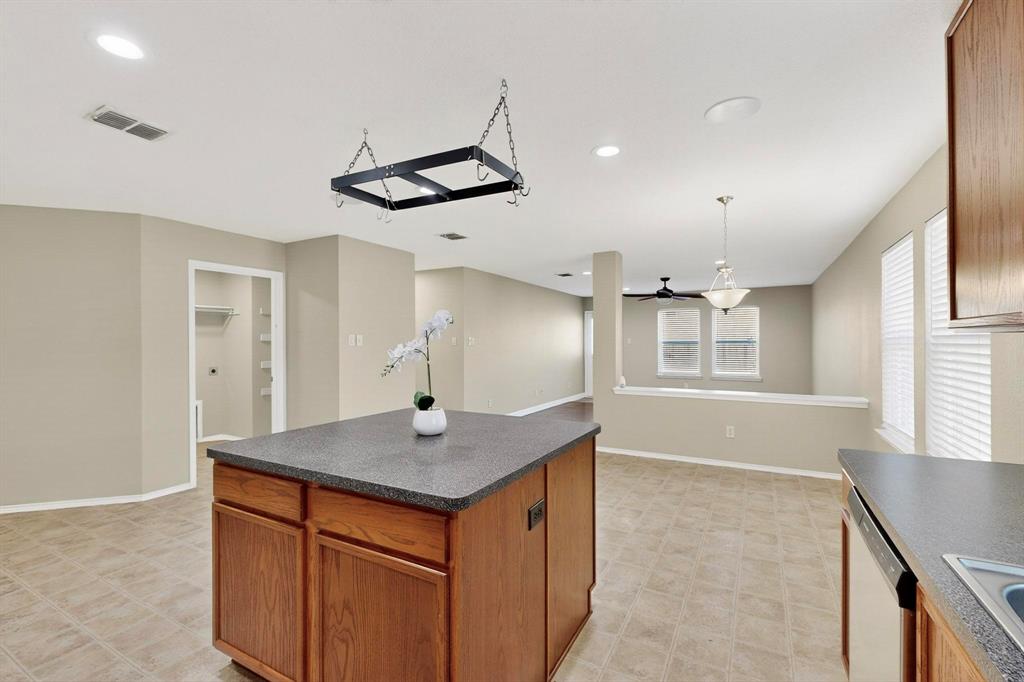 2114 Cypress Way Anna, TX 75409 - Photo 10 of 40 a kitchen with stainless steel appliances granite countertop a sink and a refrigerator