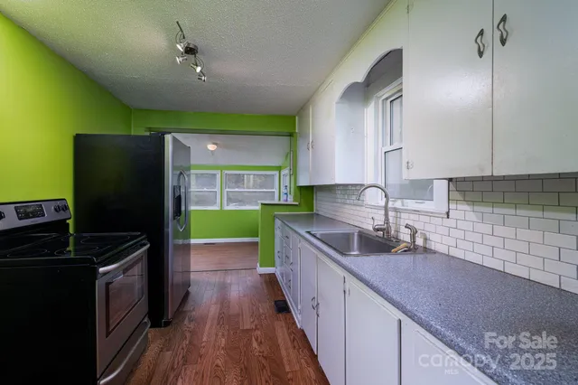 a kitchen with kitchen island granite countertop a sink a counter space appliances and cabinets