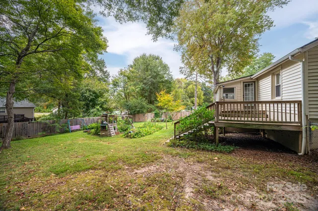a view of a backyard with a garden and deck