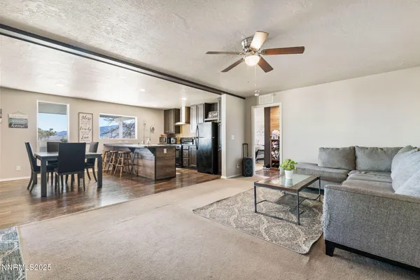 a living room with furniture kitchen view and a chandelier