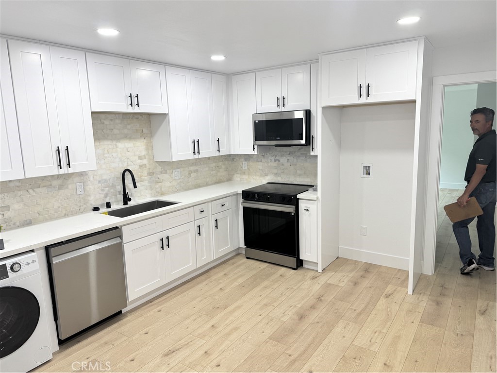 17422 Keelson Lane, Unit 3 Huntington Beach, CA 92647 - Photo 2 of 4 a kitchen with stainless steel appliances granite countertop a sink stove and refrigerator