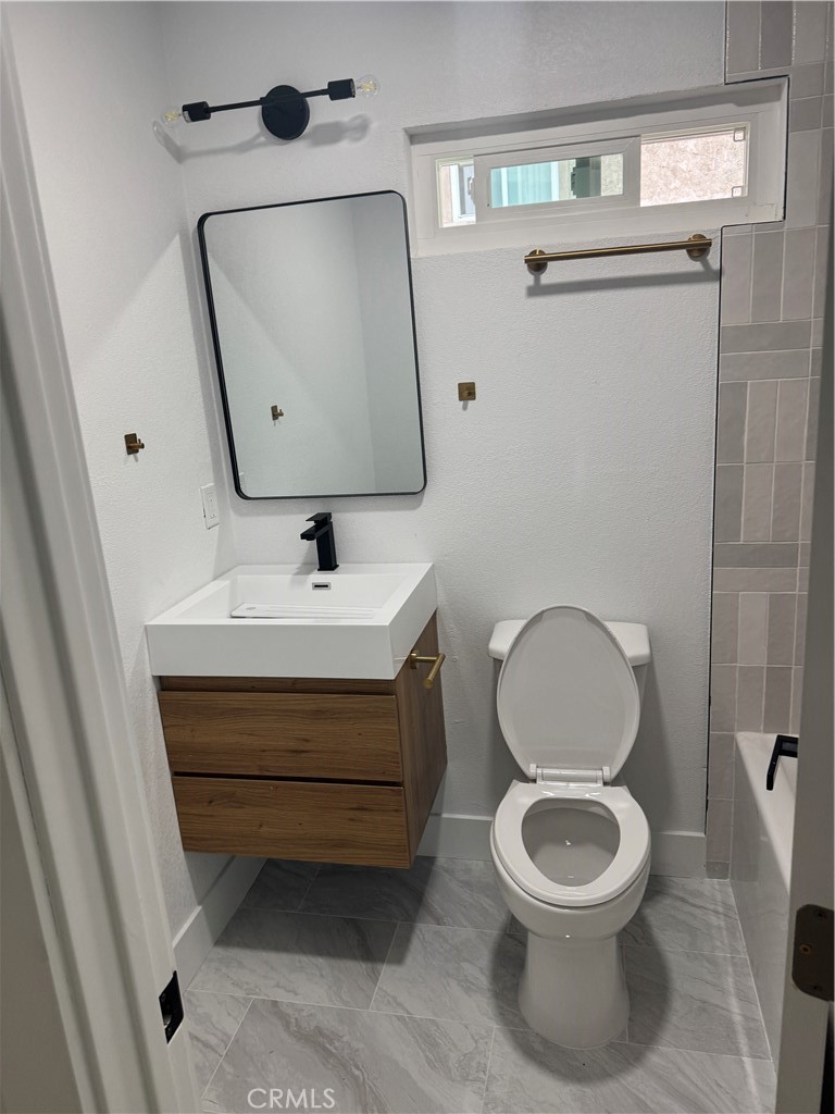 17422 Keelson Lane, Unit 3 Huntington Beach, CA 92647 - Photo 4 of 4 a bathroom with a toilet sink and mirror