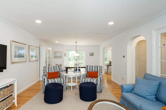 a living room with furniture kitchen view and a flat screen tv